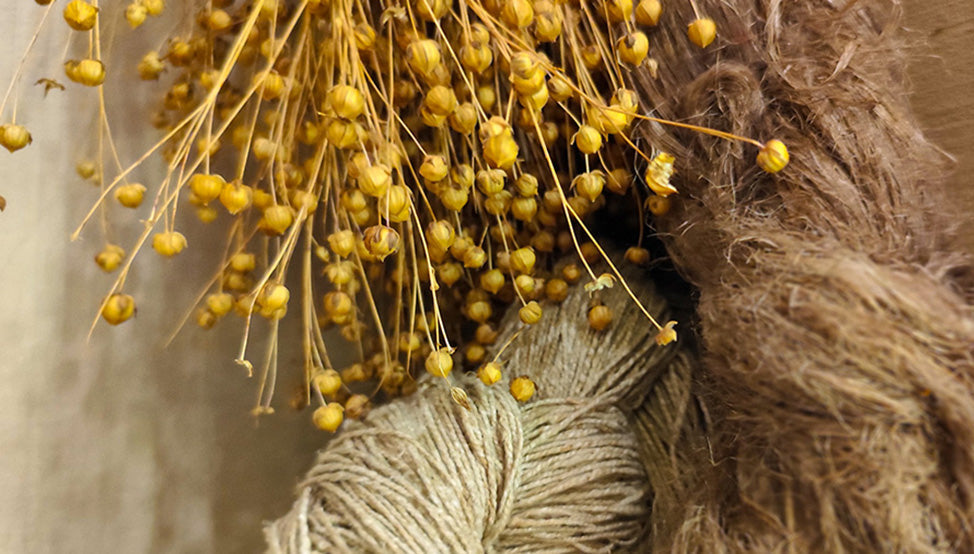Close-up of raw flax fibers, yarn, and dried flax seeds