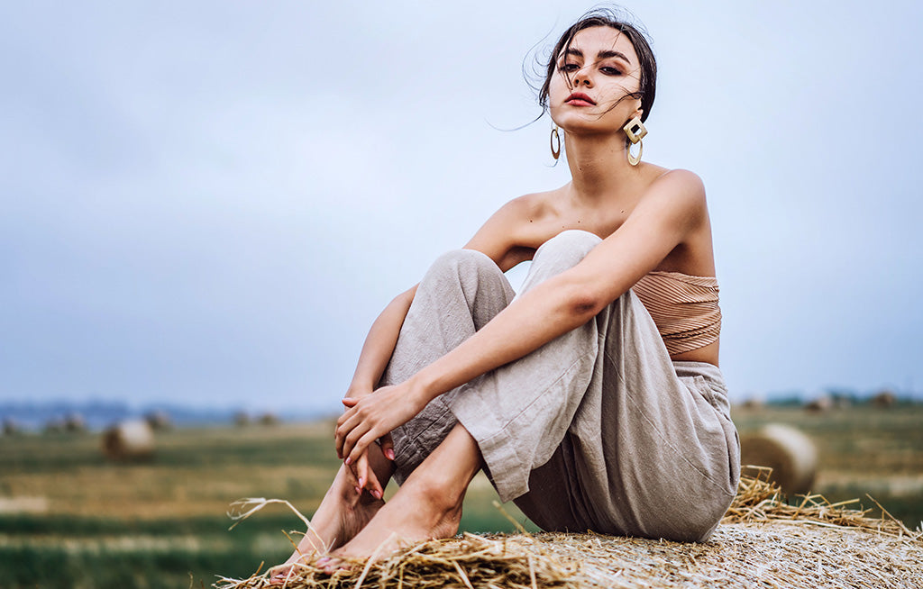 Woman sitting outdoors wearing beige linen pants and crop top