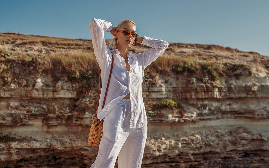Woman wearing a lightweight white summer outfit outdoors in bright sunshine