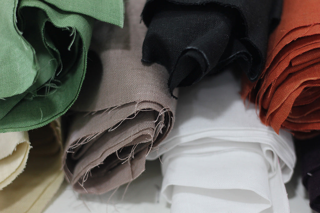 Detailed shot showing the natural colors of stacked linen textile rolls