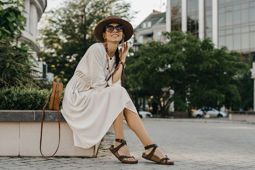 Woman wearing a comfortable linen midi dress with a relaxed flowing silhouette, styled with a sun hat