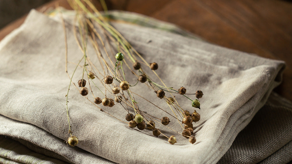 Flax stems on folded linen fabric