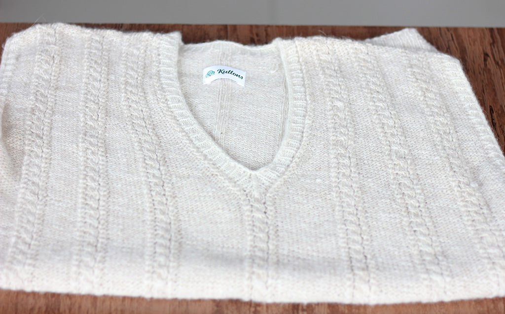Folded handcrafted Pashmina sweater by Kuttons, showcasing the soft texture and cable-knit design