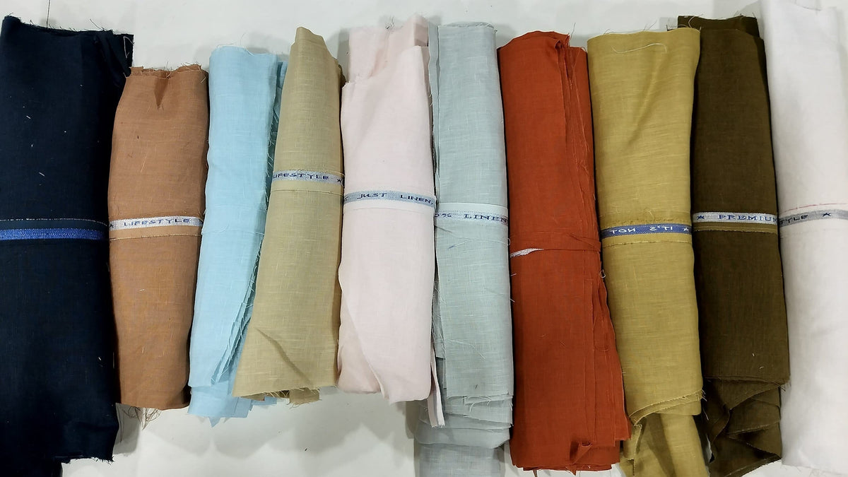 A flat lay photo showing multiple rolls of linen fabric