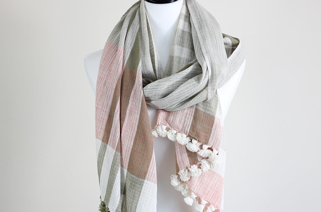 Pastel checkered organic cotton scarf with white tassels displayed on a mannequin