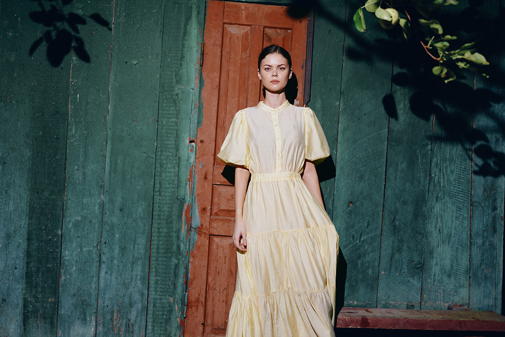 Elegant woman wearing a yellow linen midi dress with puff sleeves, perfect breathable summer outfit for women
