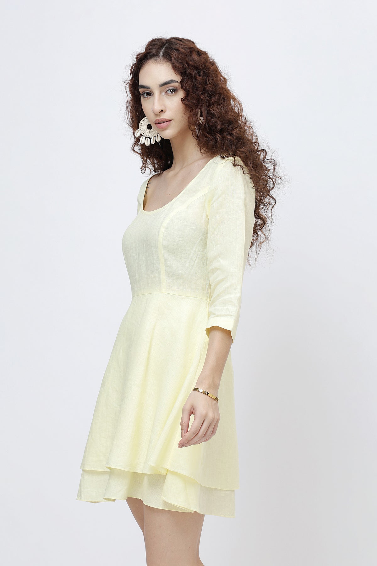 Woman wearing a light yellow dress against a white background