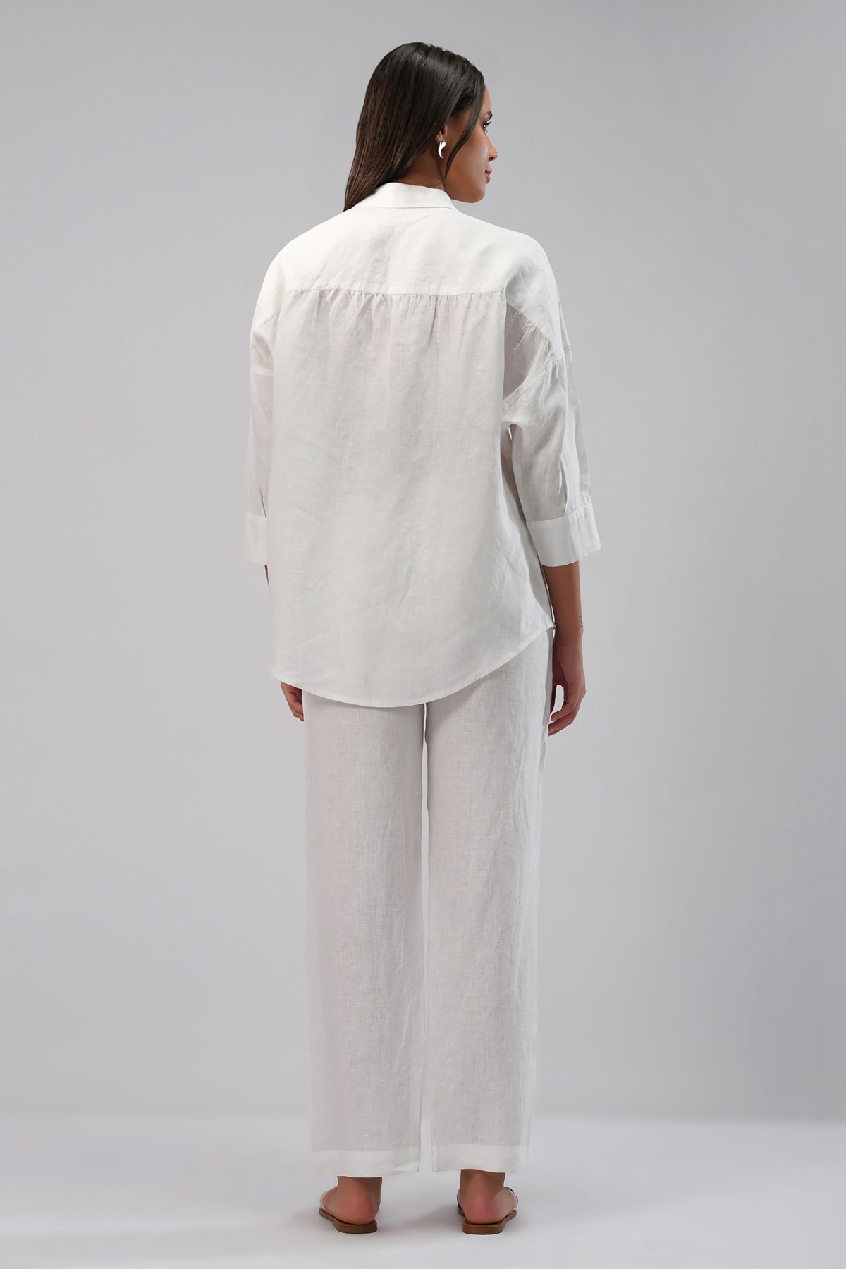 Woman wearing a white linen pants and shirt outfit