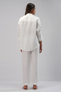 Woman wearing a white linen pants and shirt outfit