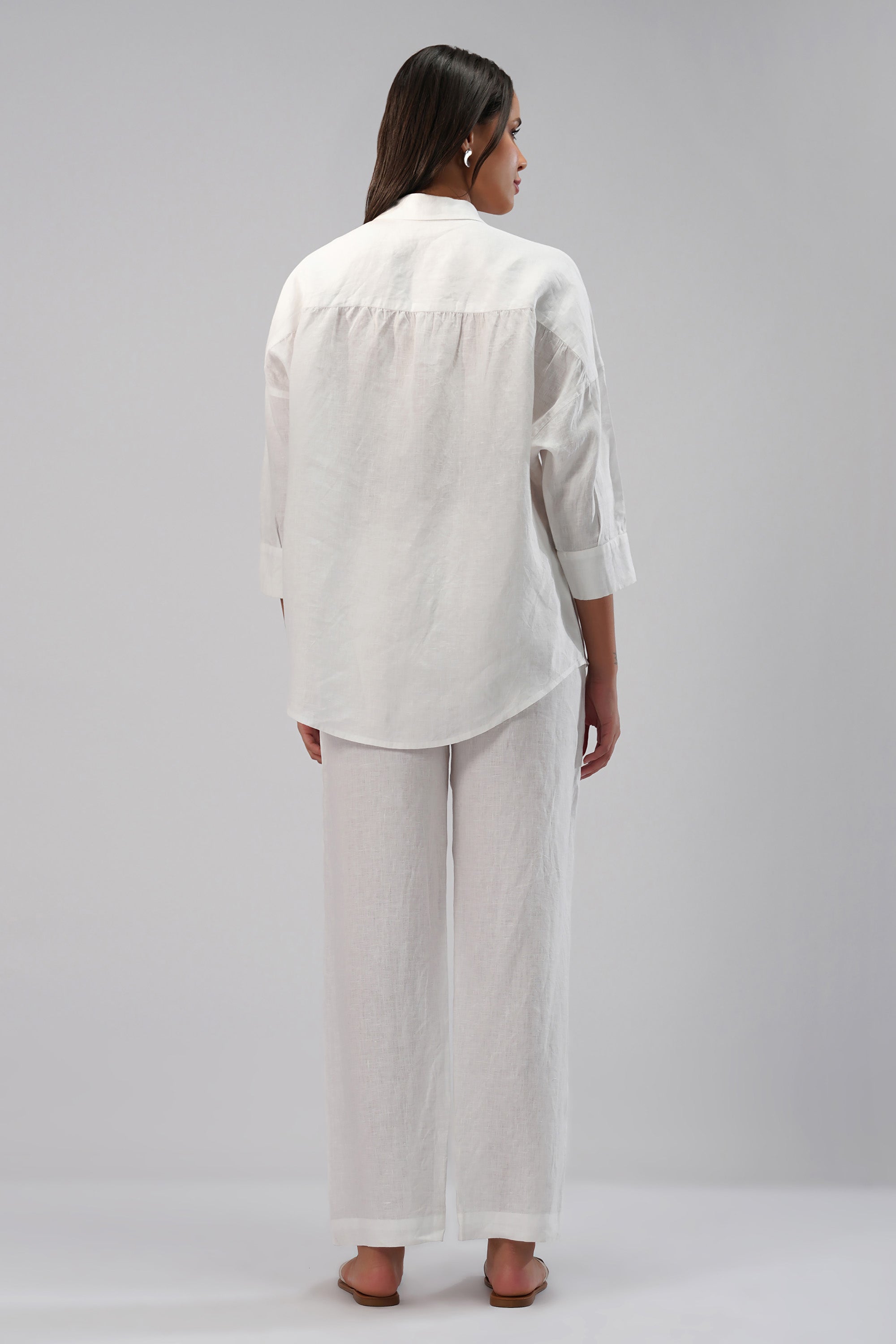 Woman wearing a white linen pants and shirt outfit