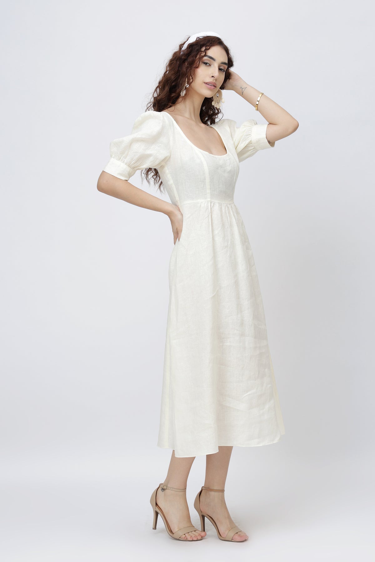 Woman wearing an ivory European linen dress with puff sleeves