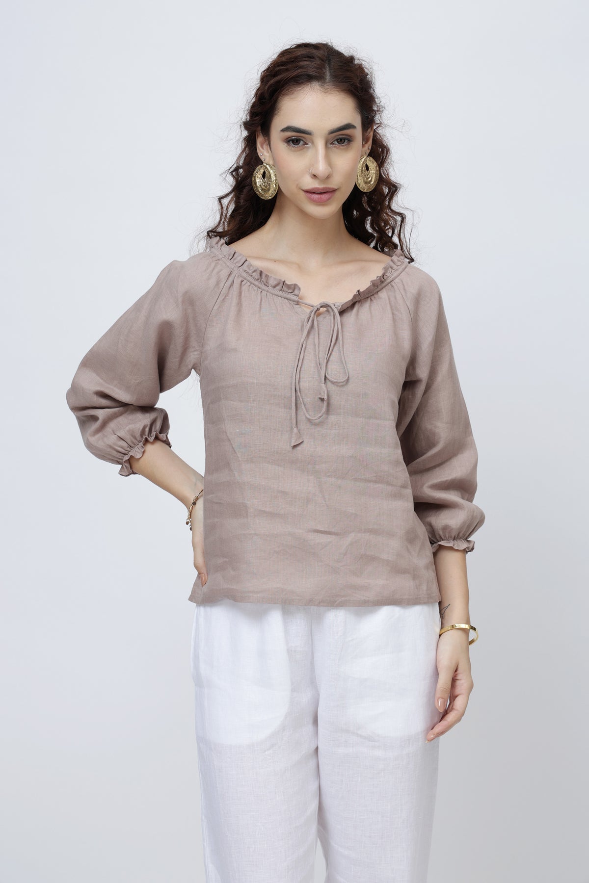 Close-up of soft ruffle neckline with tie detail on linen top