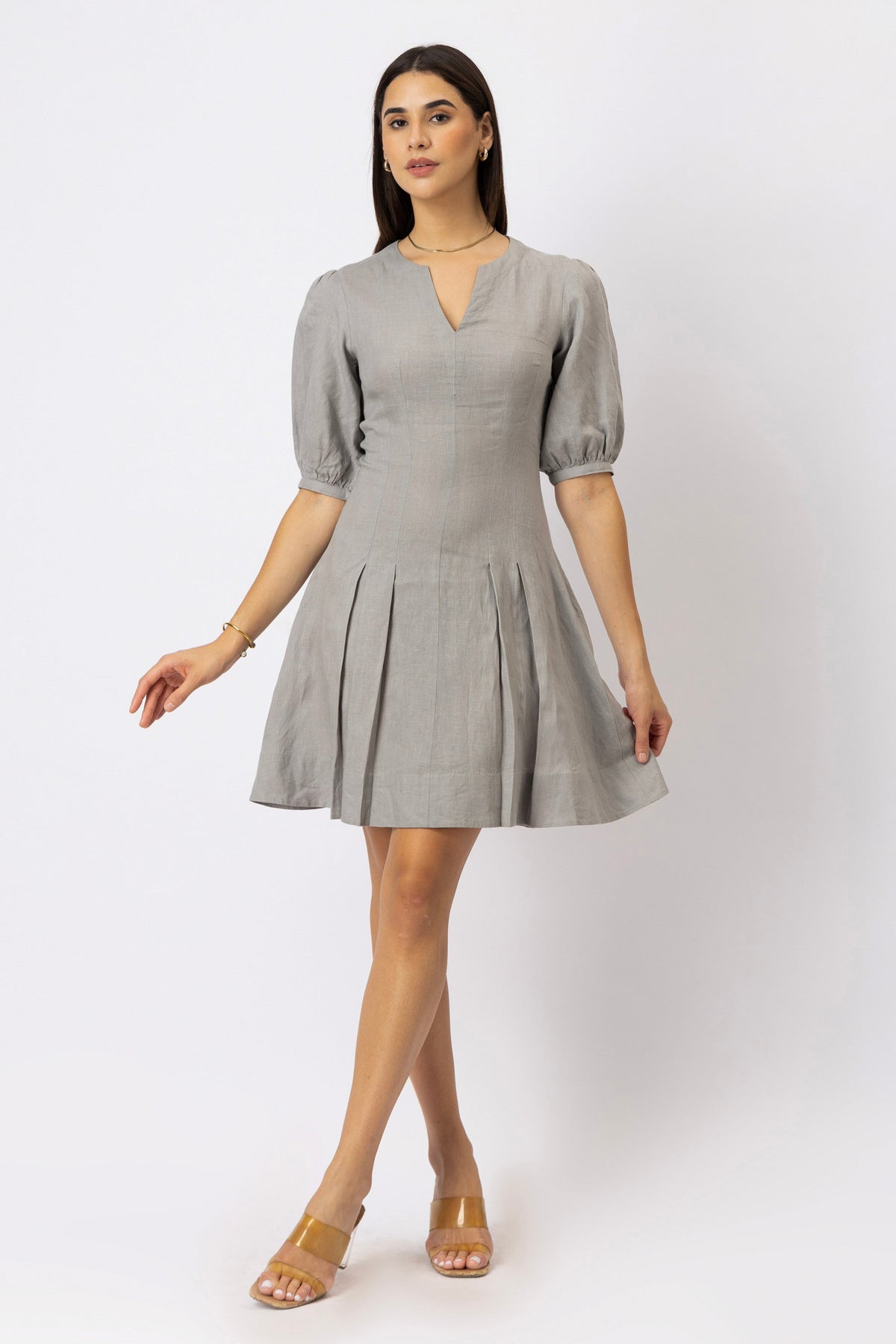 Front view of the split V-neck linen mini dress with a tailored bodice, elbow-length puff sleeves, and a pleated fit-and-flare skirt