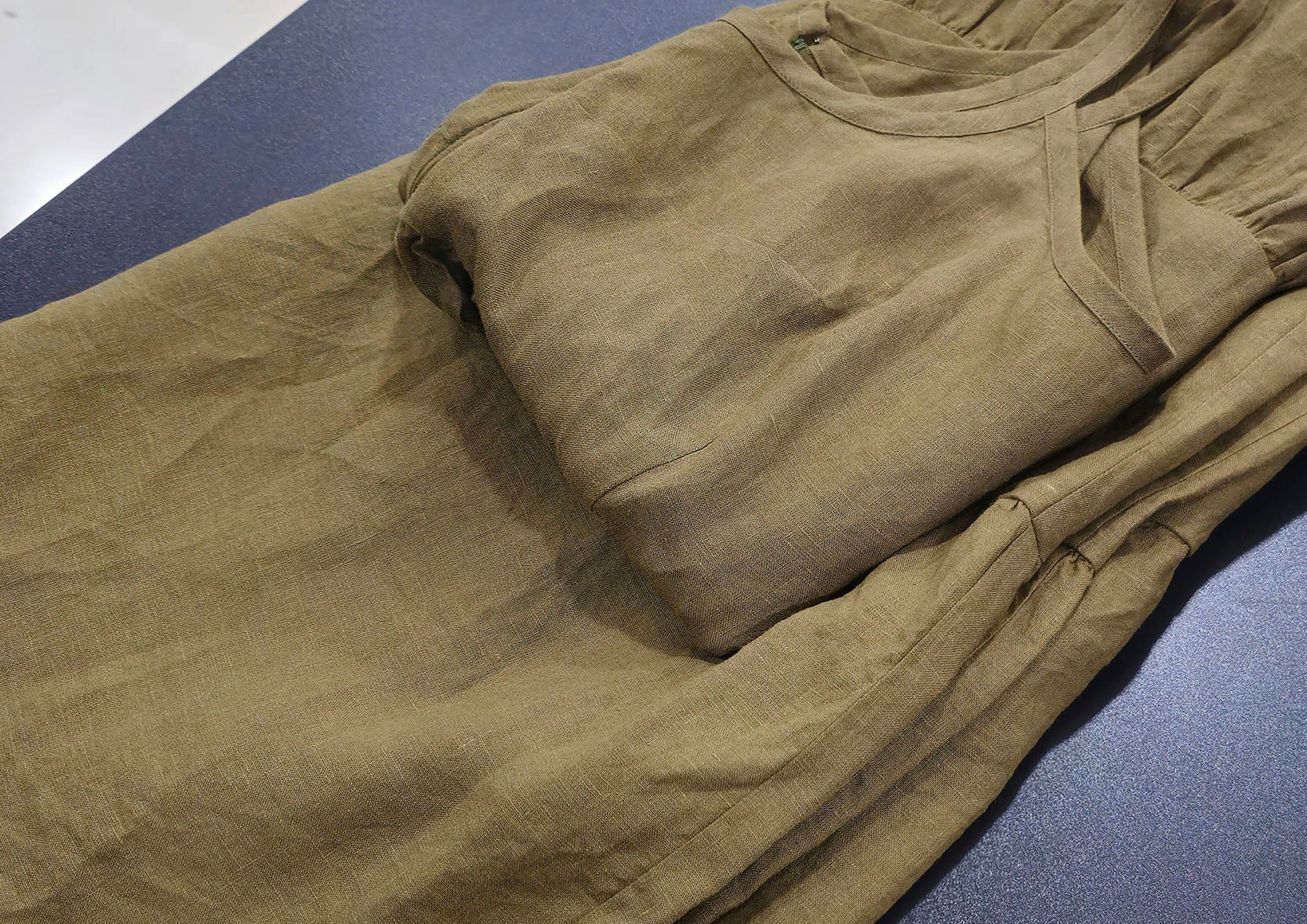 olive color linen dress on table