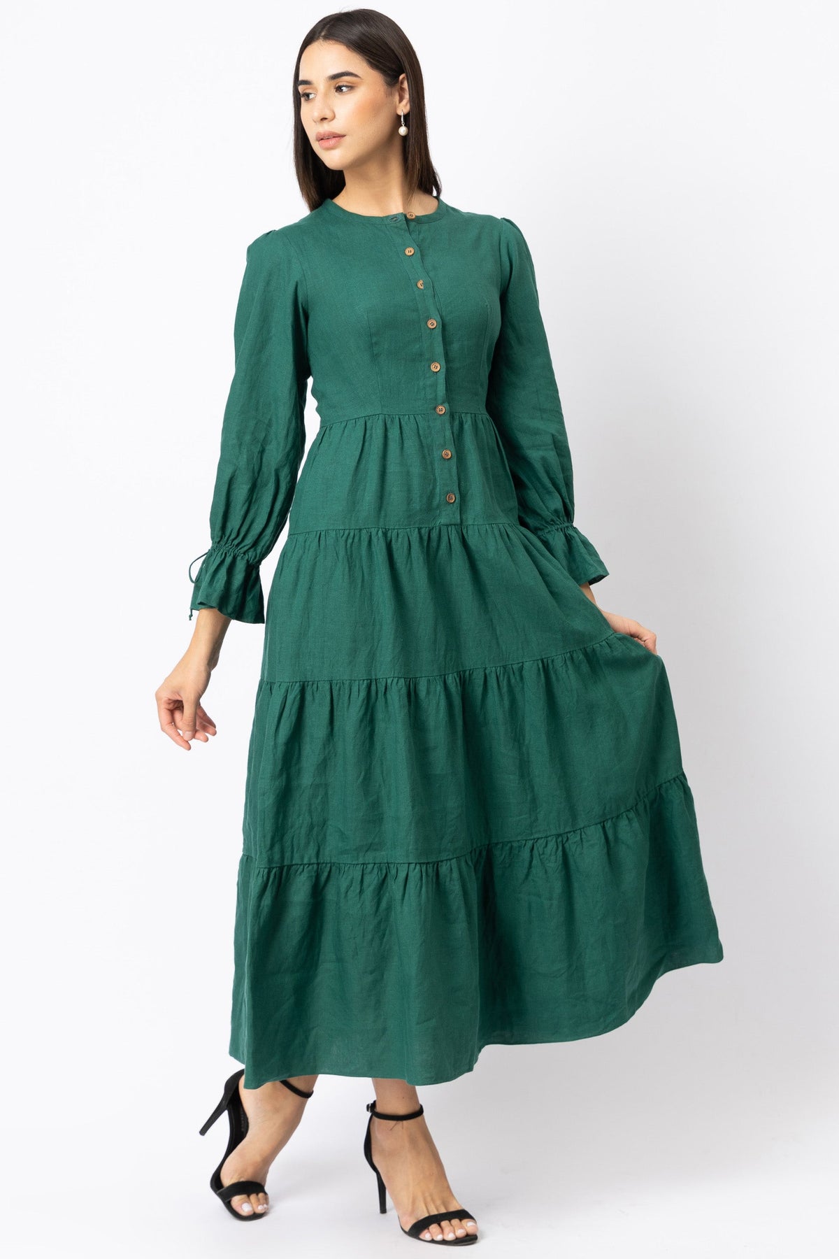 Woman wearing a green linen dress with tiered layers