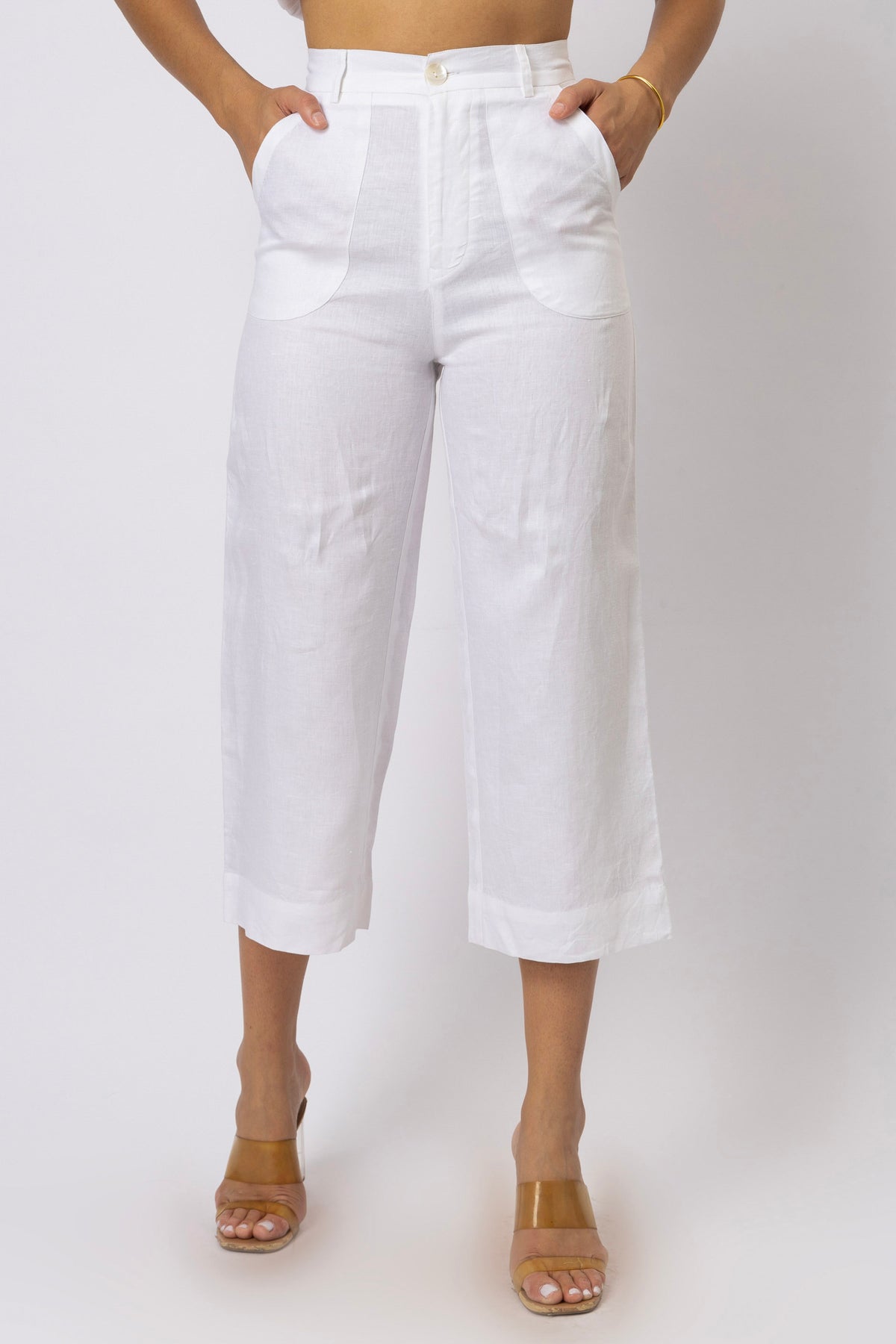 Front view of high-waisted linen capri pants featuring rounded patch pockets, a button closure, belt loops, and a cropped straight-leg silhouette