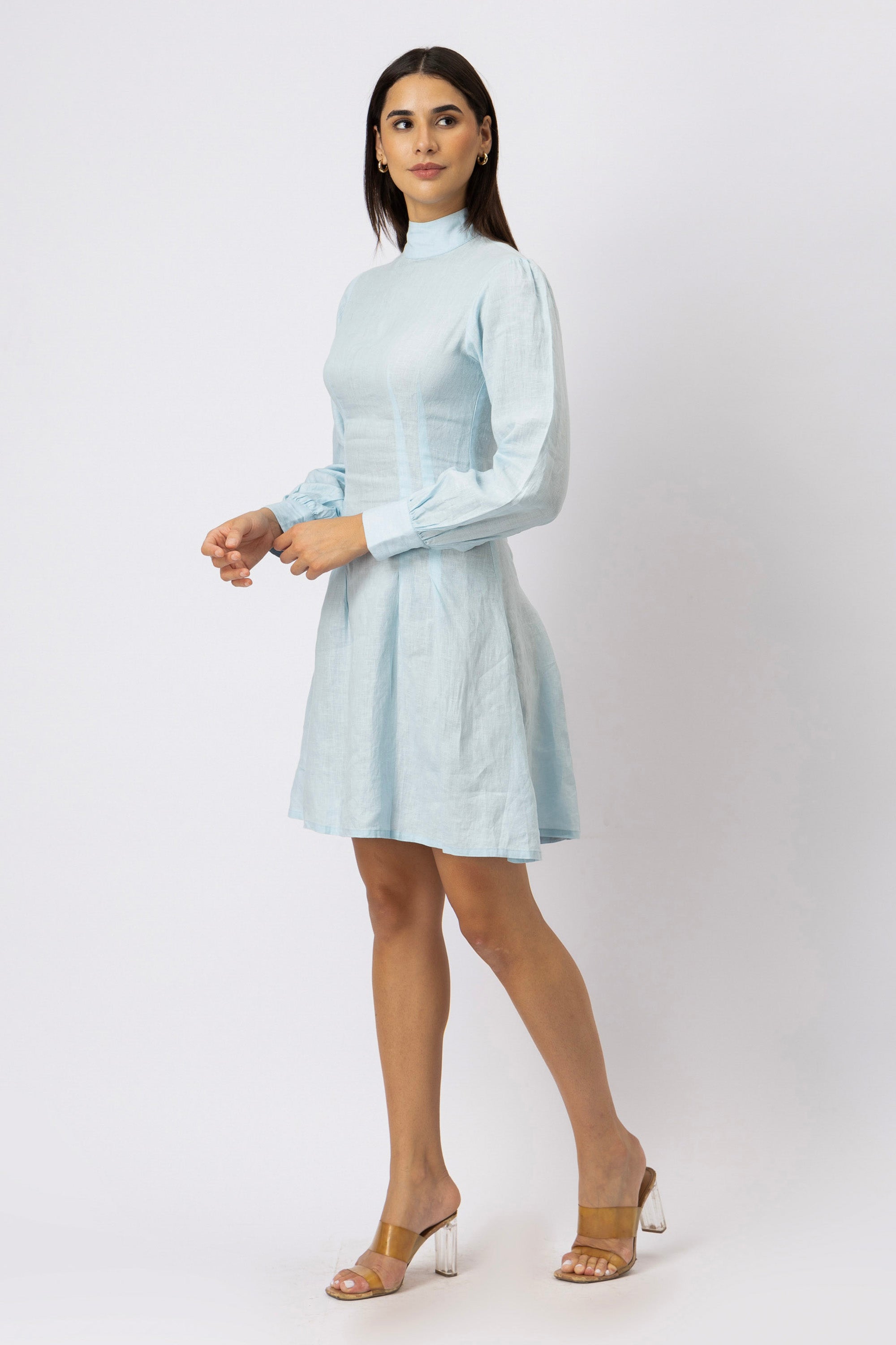 Side angle view of an ice blue European linen mock neck mini dress with long bishop sleeves