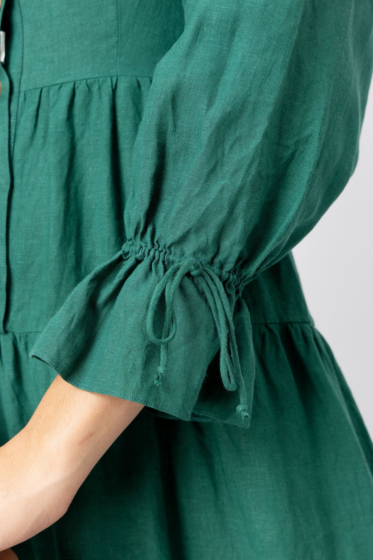 Gathered long sleeve with adjustable tie cuff on green linen maxi dress