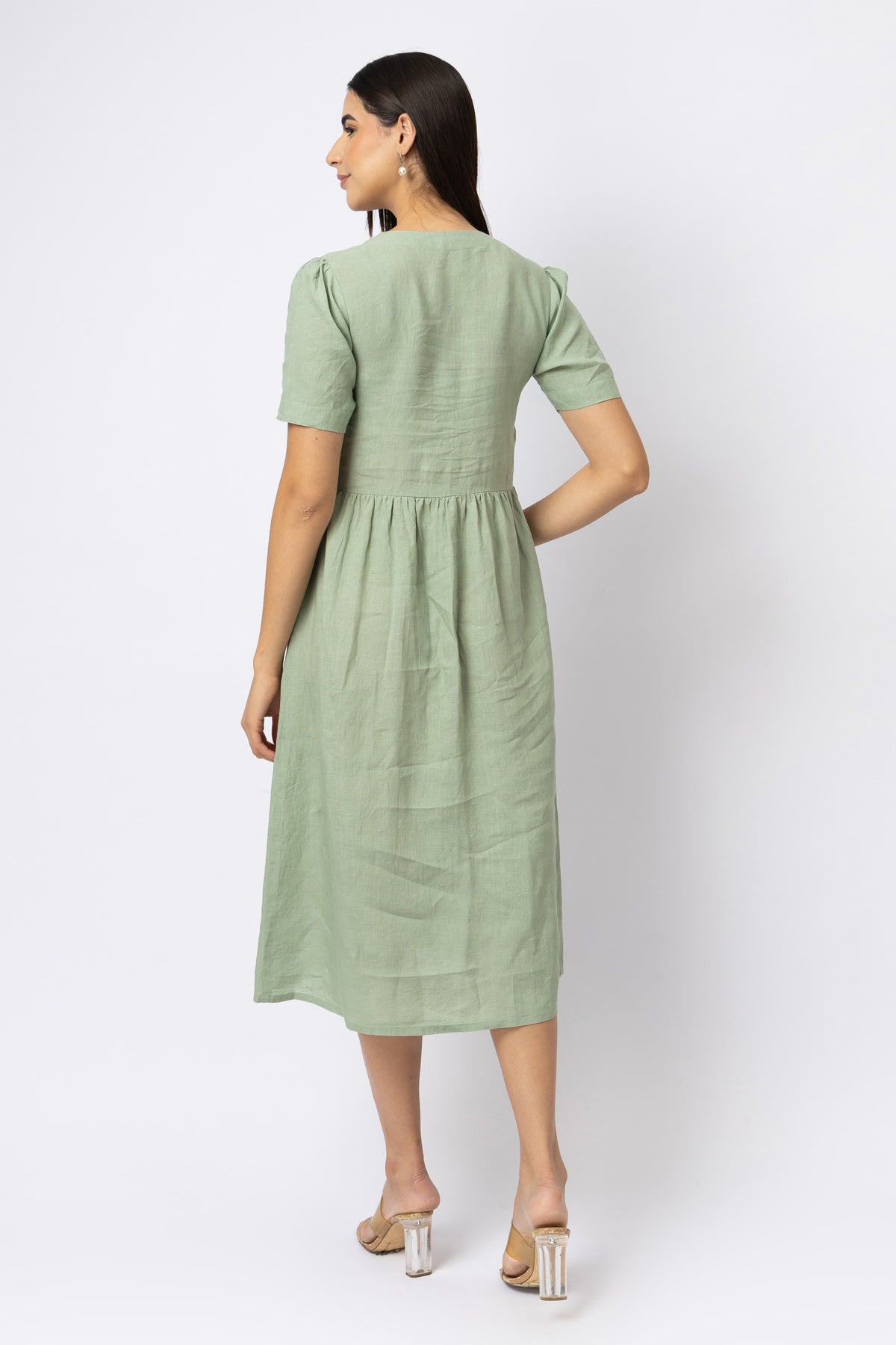 Back view of sage green linen midi dress with short sleeves and gathered waist