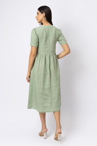Back view of sage green linen midi dress with short sleeves and gathered waist