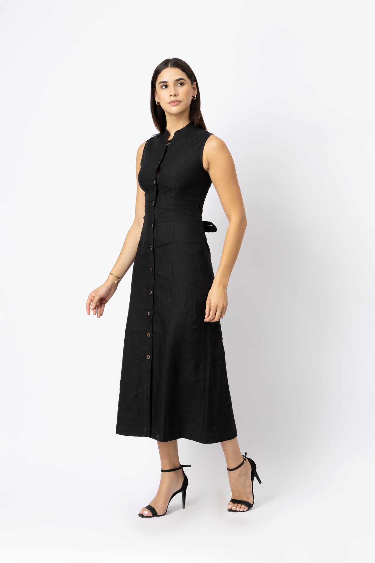 Side view of black sleeveless linen midi dress with button front and shaped waist