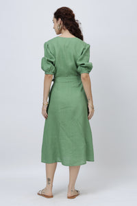 Woman wearing a green linen dress with puff sleeves