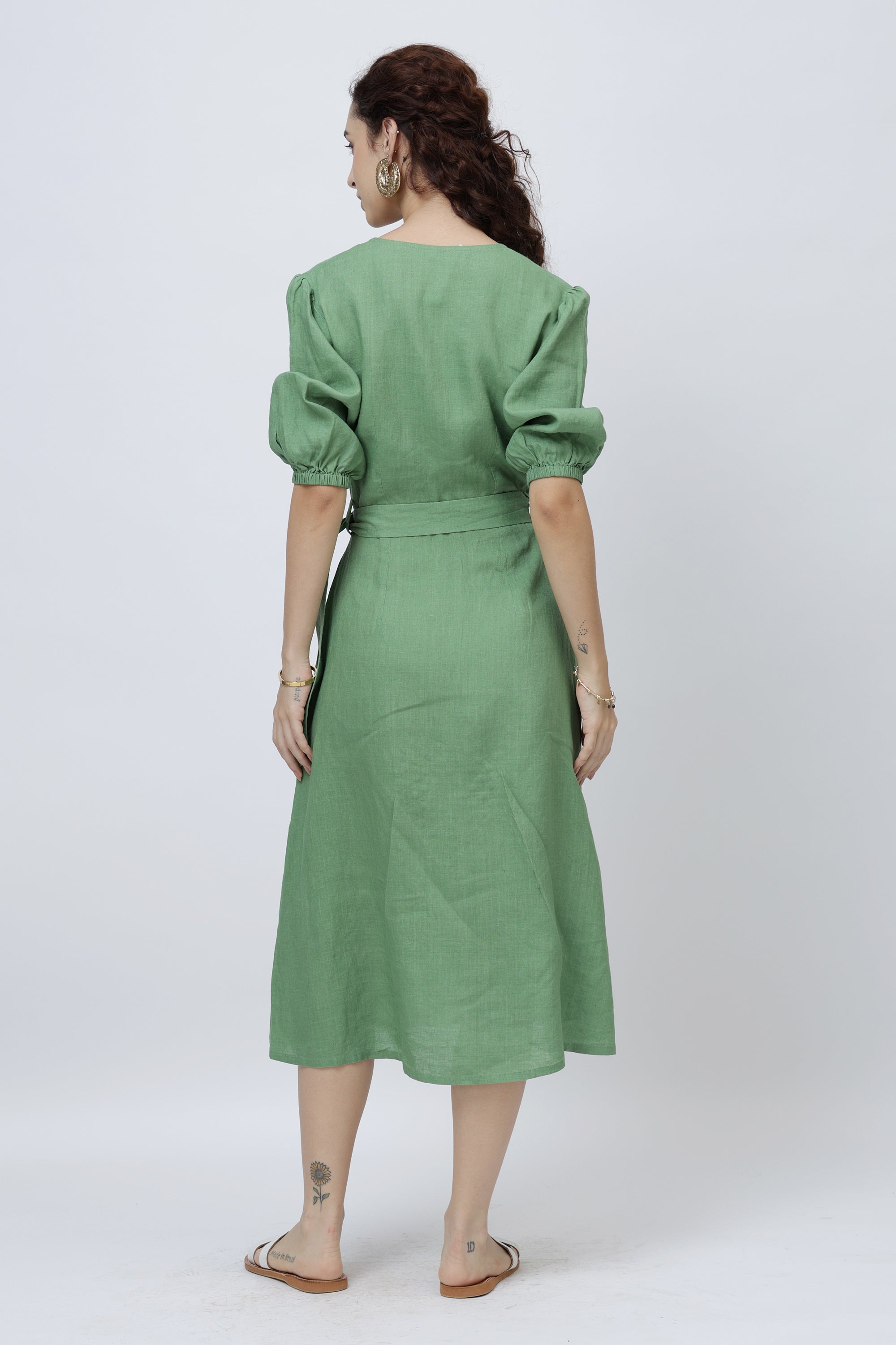 Woman wearing a green linen dress with puff sleeves