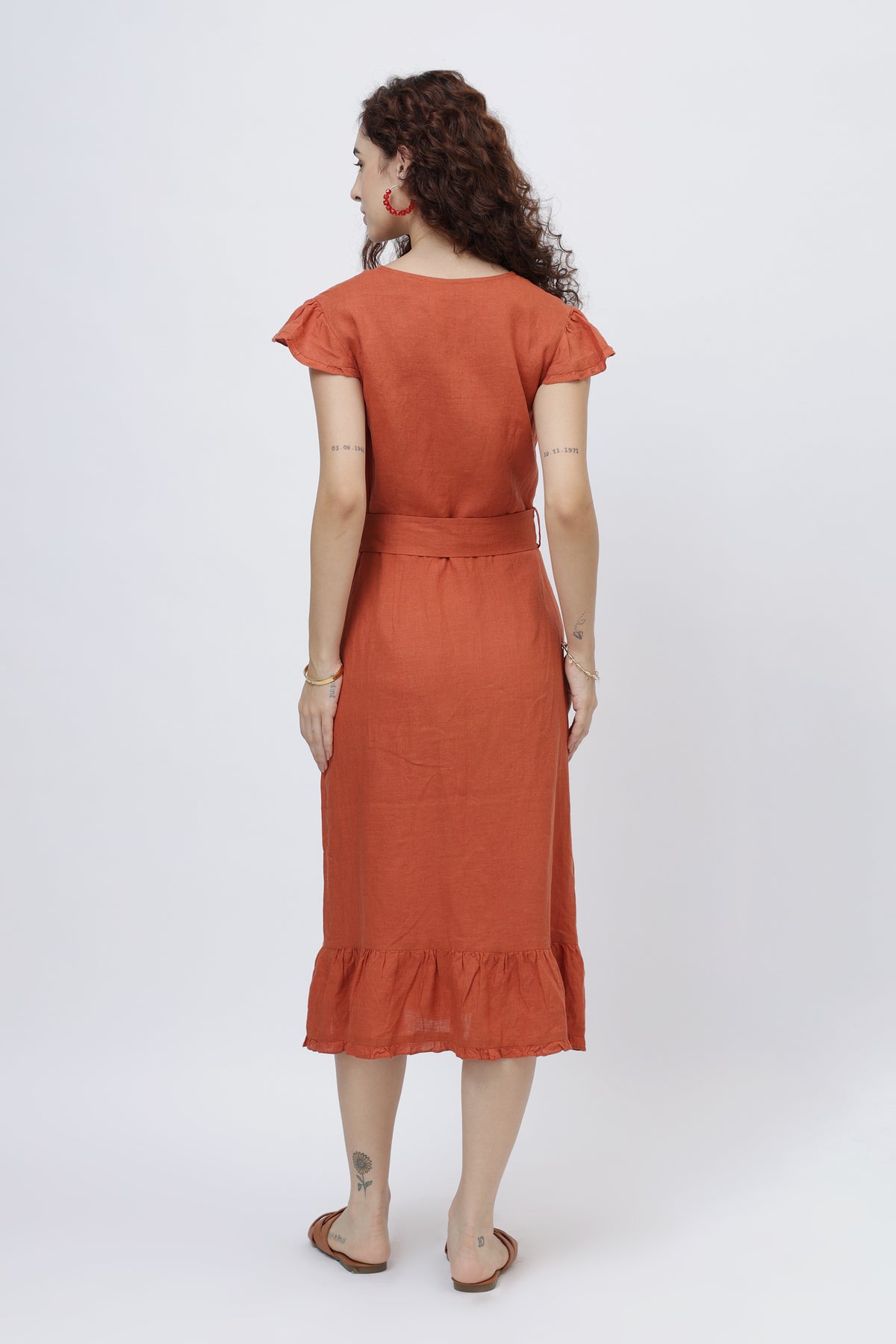 Woman wearing a rust-red linen wrap dress