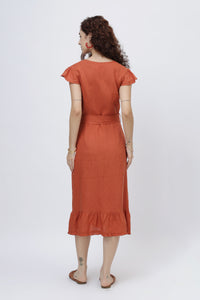Woman wearing a rust-red linen wrap dress
