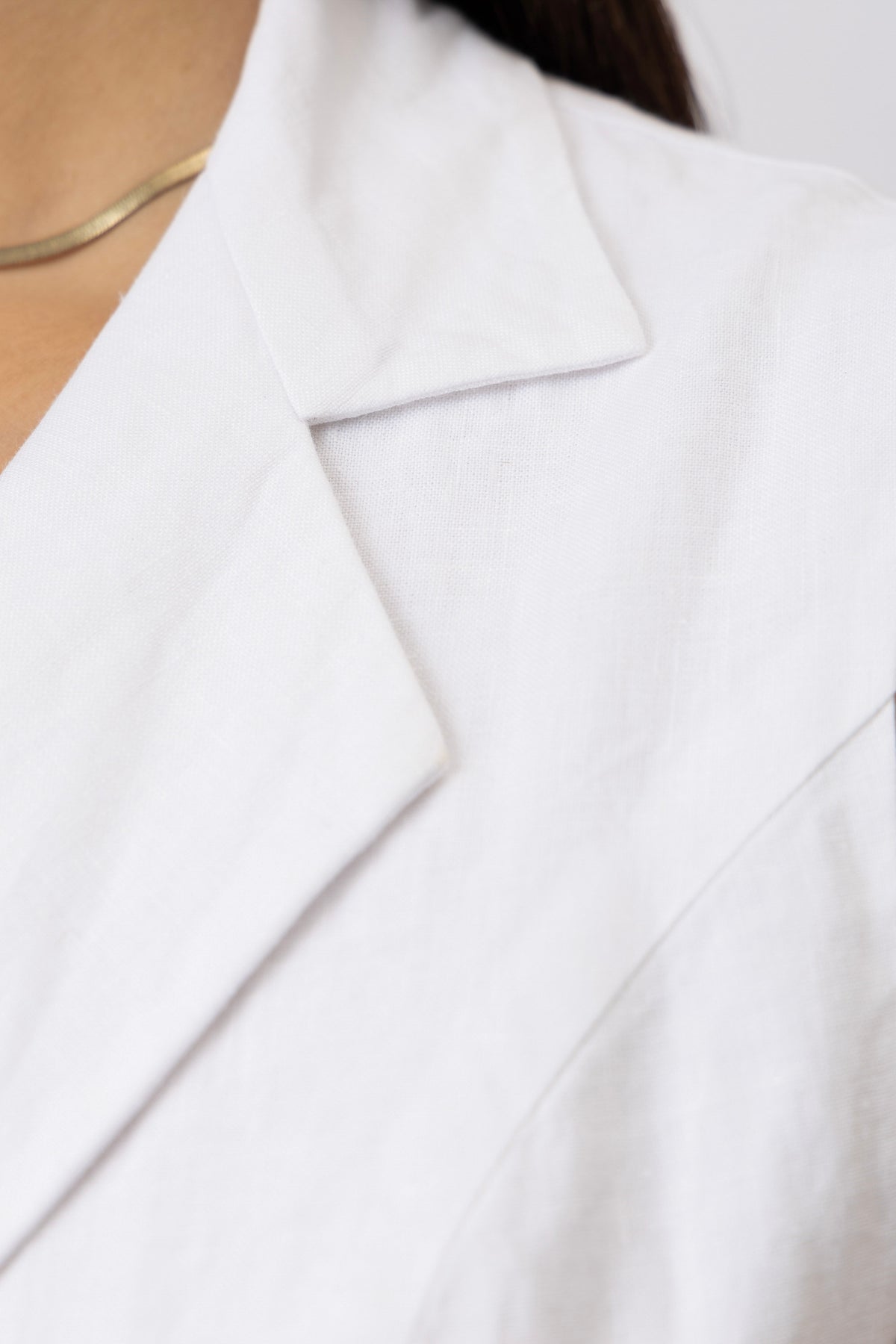 Close-up of linen blazer mini dress showing tailored lapels and fine fabric texture