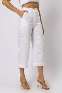 Three-quarter front view of high-waisted linen capri pants featuring curved front patch pockets