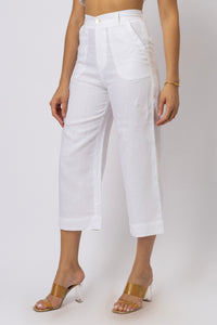 Side-angle view of high-waisted linen capri pants showing the straight-leg silhouette, curved front pocket, waistband, and cropped hem