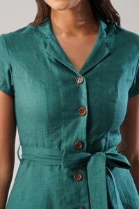 Close-up detail of a linen dress featuring a notched collar, wooden buttons, short sleeves, and a tie waist