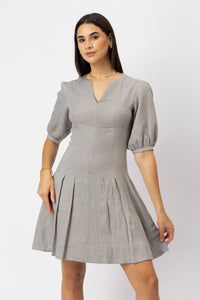 Women's tailored linen mini dress highlighting the fitted bodice, V-neckline, elbow-length puff sleeves, and structured pleated skirt