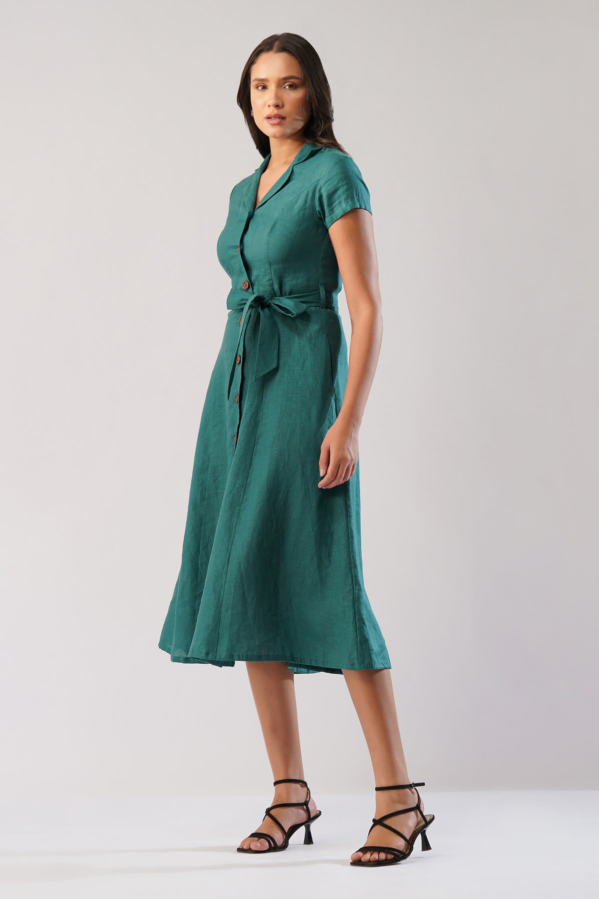Side view of a linen midi dress with notched collar, short sleeves, button front and waist tie