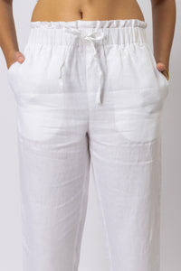 Close-up of women's linen pants featuring an elasticated paperbag waist and adjustable drawstring
