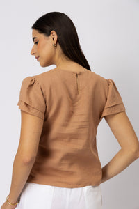Close-up back view of a linen top featuring layered flutter sleeves and a keyhole button closure