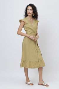 Woman wearing a khaki European linen dress with ruffled sleeves and hem