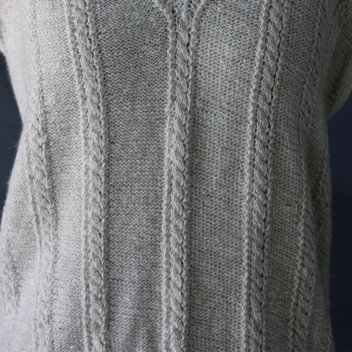 Close-up of a light pashmina cashmere sweater showing the detailed handknit pattern and texture.