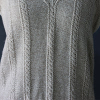 Close-up of a light pashmina cashmere sweater showing the detailed handknit pattern and texture.