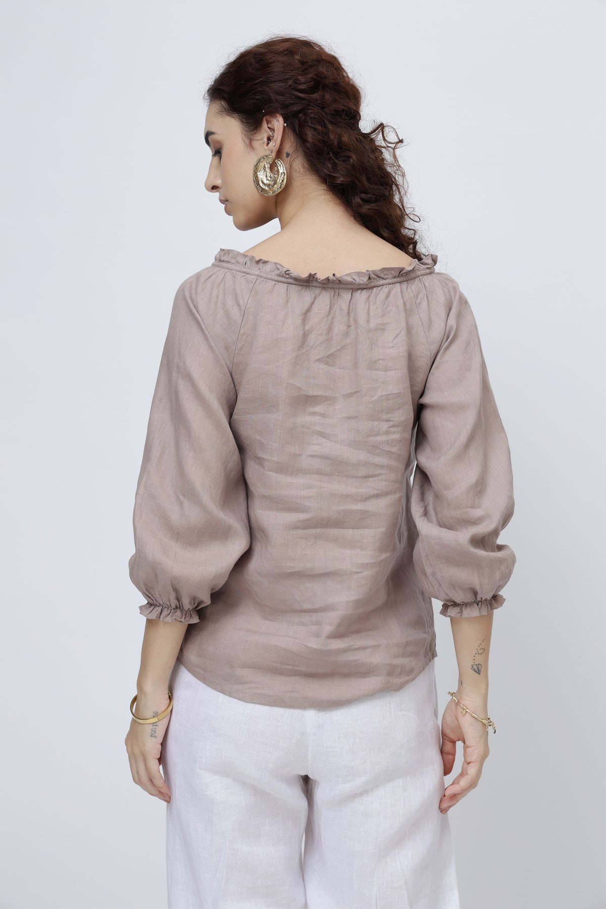Back view of women’s linen blouse with ruffle neckline and relaxed fit