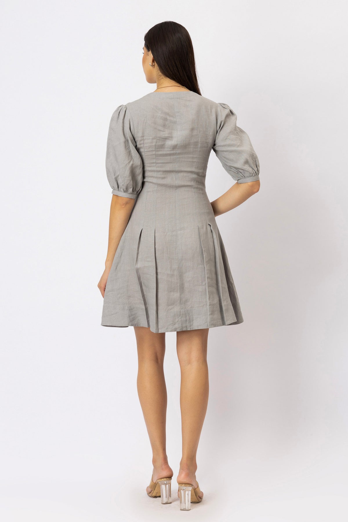 Back view of the split V-neck linen mini dress featuring a tailored bodice, fit-and-flare silhouette
