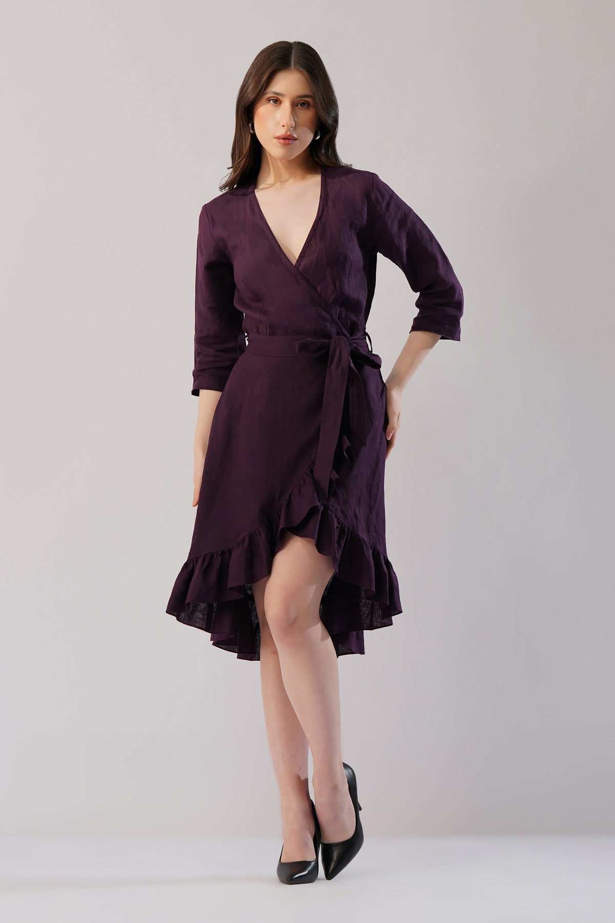 woman wearing plum european linen wrap dress with ruffle hem front view