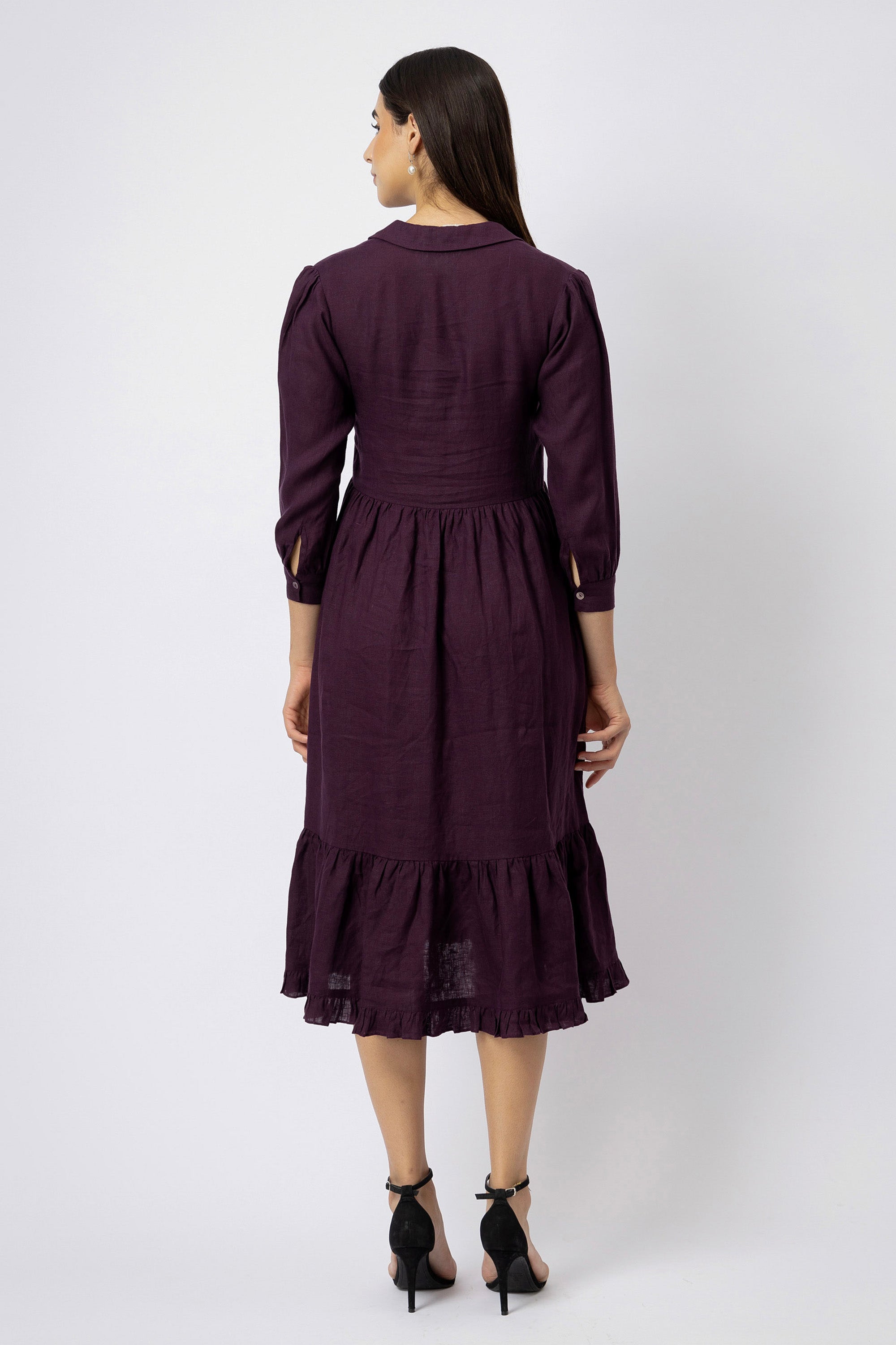 Back view of a long-sleeve linen shirt dress with a collared neckline, fitted waist, gathered skirt, and tiered midi-length hem