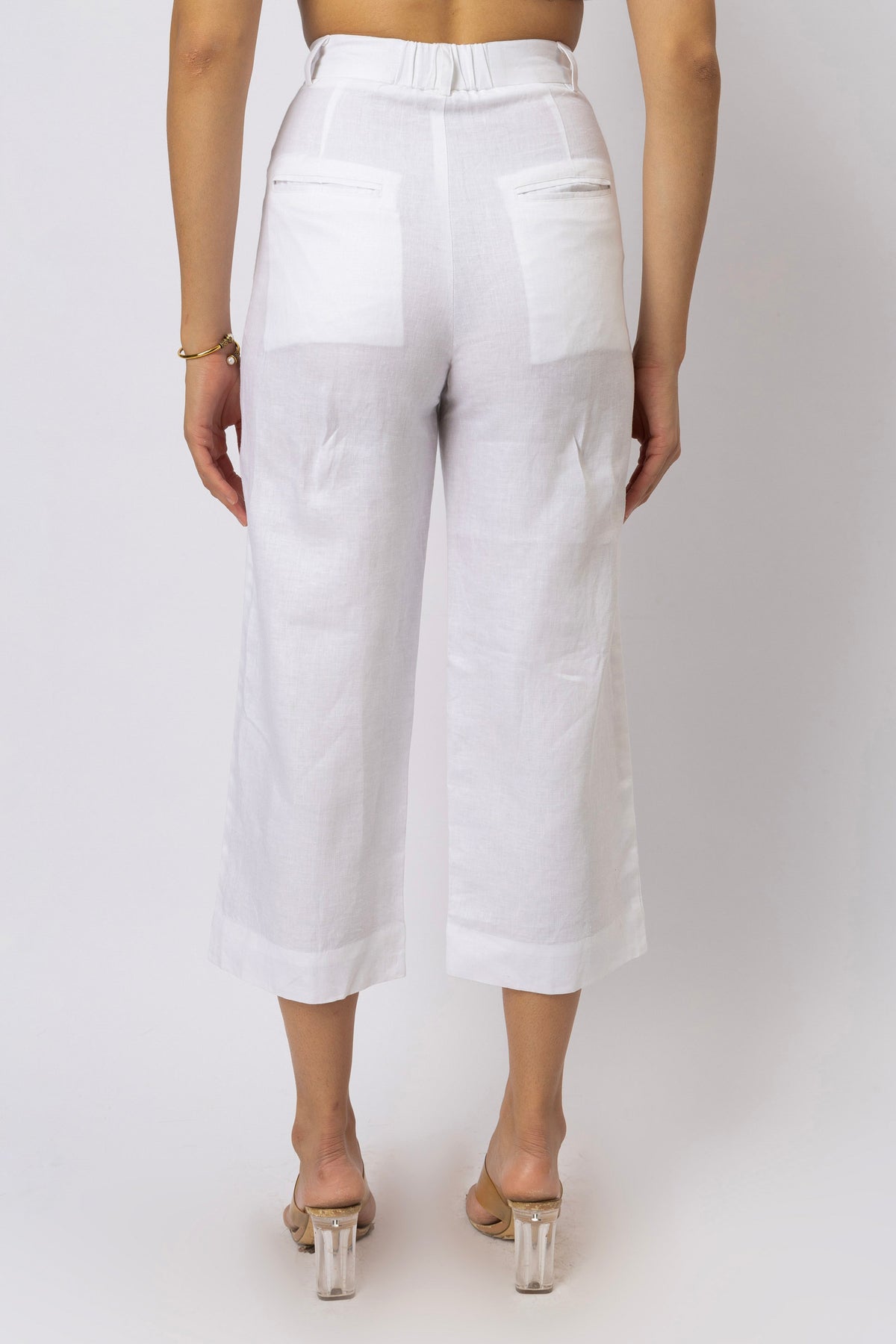 White high-waisted linen capri pants with back patch pockets and a relaxed straight-leg fit